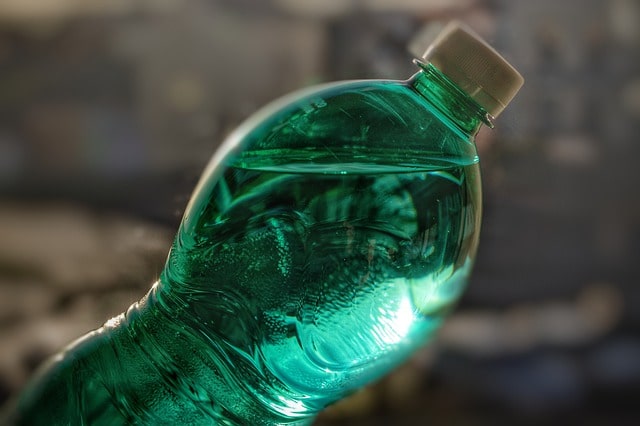 botella verde de plástico cargada de agua
