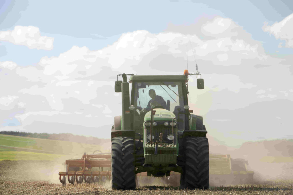 tractor cosechando con trabajador agrícola o agrónomo debajo del sol con altas temperaturas que pueden provocar deshidratación en las personas que trabajan a cielo abierto
